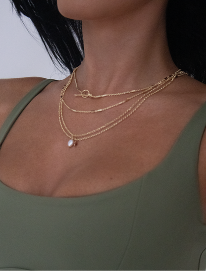 custom necklace stack with dainty gold chains, gold toggle necklace, pearl pendant gold and natural gemstone necklace