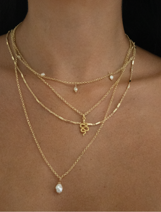 minimalist jewelry stack with gold chains, pearl necklace gold, snake necklace gold and dainty pearl necklace gold. Temple of the sun snake necklace